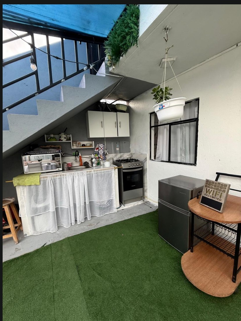 Cocina bajo la escalera con césped sintético
