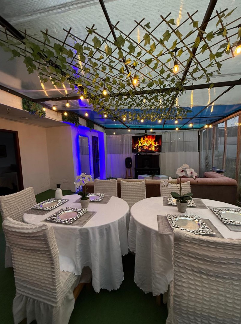 Sala con luces cálidas y pérgola de vid