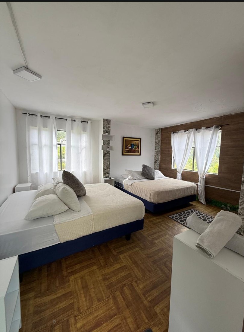 Habitación matrimonial con dos camas y detalles en madera